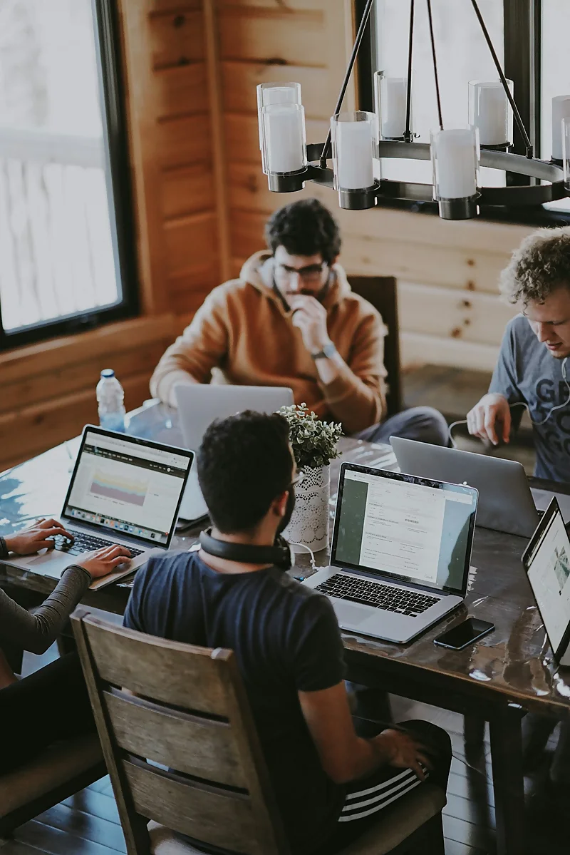 Equipo de trabajo analizando información con computadoras; imagen referencial